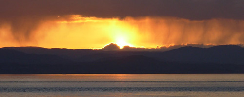 sun setting over the island