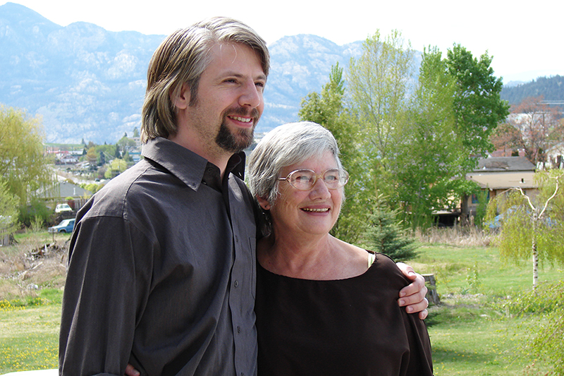 Raine Powell with her son Mathieu outdoors on a farm.
