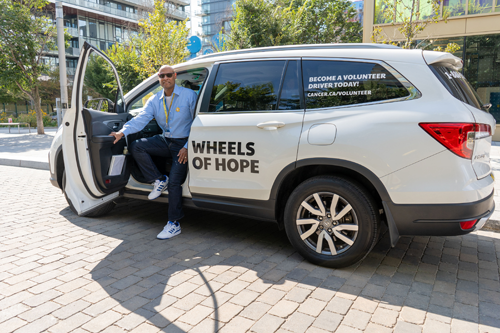 Volunteer driver getting out of a Wheels of Hope vehicle.